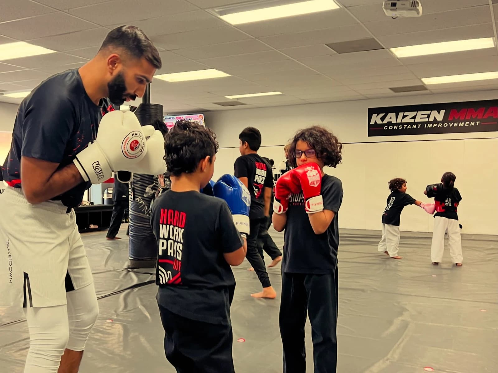Children practicing martial arts with a coach at Kaizen MMA in Mechanicsburg